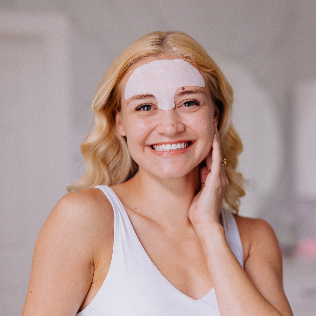 woman wearing frownies soft cotton forehead serum patch for fine lines