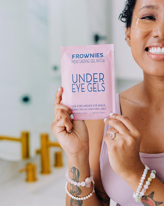 woman smiling holding a package of frownies under eye gels
