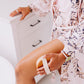 close up of woman's hand holding round body brush with natural boar's hair bristles massaging thigh for lymphatic drainage
