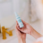 Frownies calming toner being held in hands 
