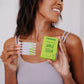A black woman shown holding Frownies apple serum package and serum in her hands