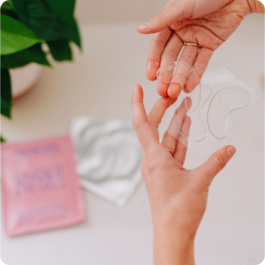 woman taking frownies eye gels out of their packaging 