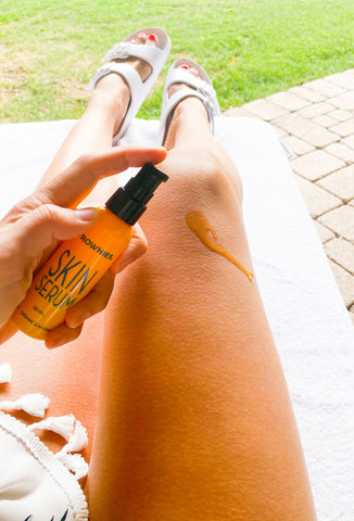 woman's legs with yellow bottle of Frownies Skin Serum