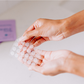 woman's hands holding sheet of transparent round pimple patch stickers
