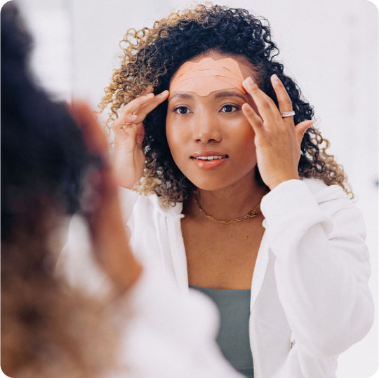 woman applying wrinkle patches to her forehead