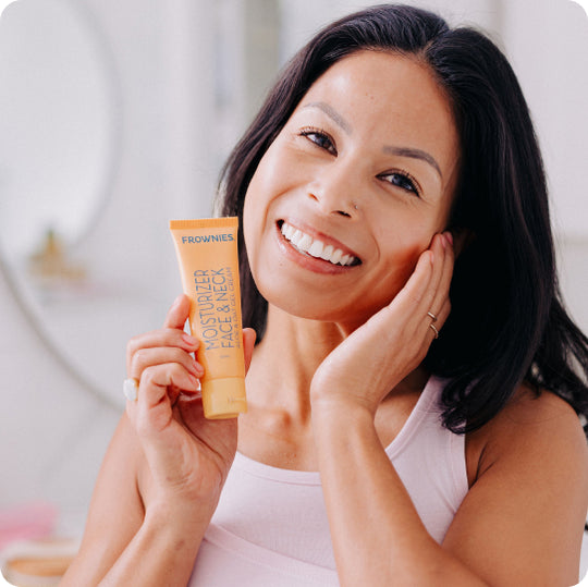 woman holding organic aloe vera face lotion touching her cheek